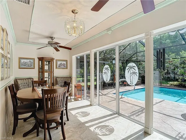 View of swimming pool featuring ceiling fan with notable chandelier