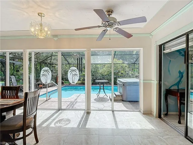 View of swimming pool with ceiling fan with notable chandelier