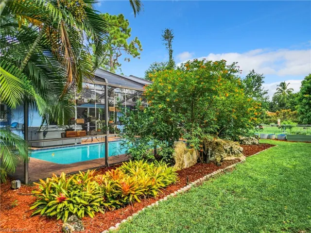 View of swimming pool with a lawn and glass enclosure