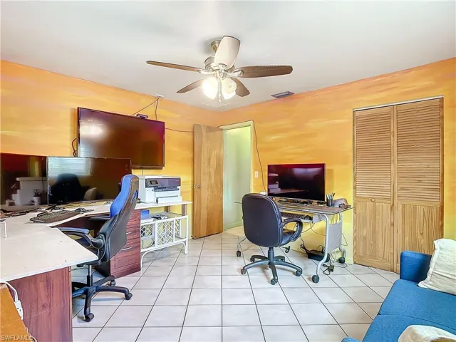 Office space with light tile patterned flooring and ceiling fan