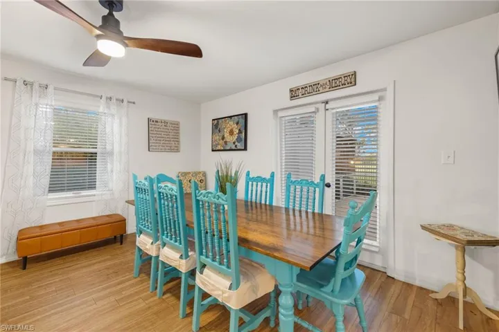 Dining area with wood-type flooring, ceiling fan, and french doors