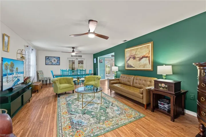 Living room with ceiling fan and hardwood / wood-style flooring