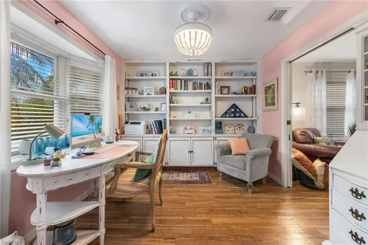 Office area with a notable chandelier and wood-type flooring
