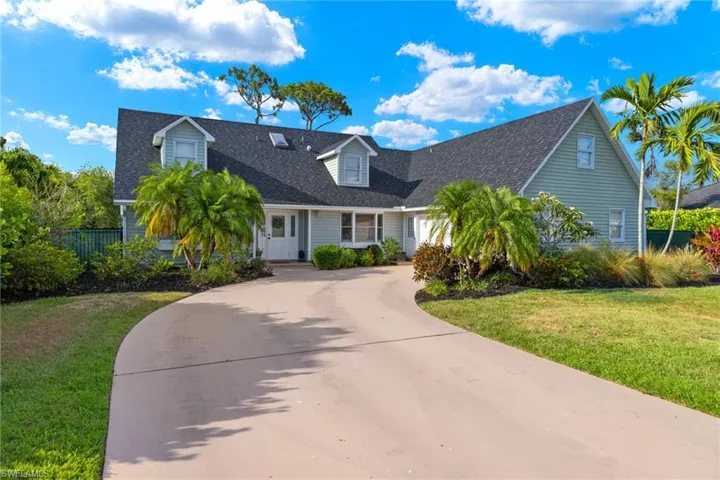 New england style home featuring a front lawn and a porch