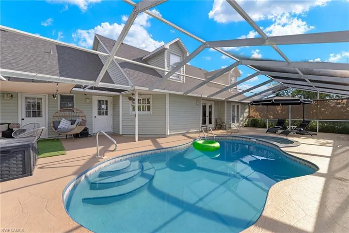View of pool featuring a patio and glass enclosure