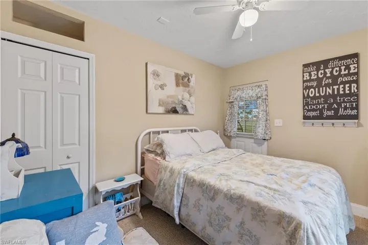 Carpeted bedroom featuring a closet and ceiling fan