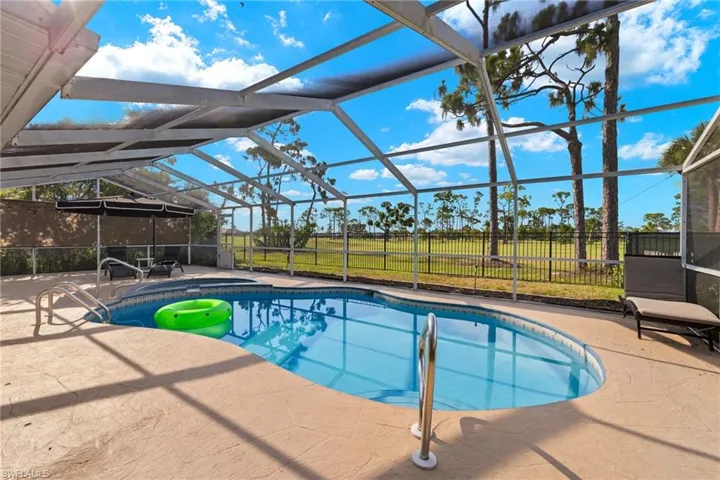 View of swimming pool featuring a lawn, glass enclosure, and a patio