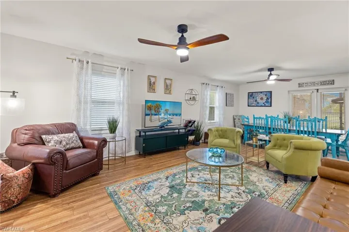 Living room with ceiling fan and light hardwood / wood-style flooring