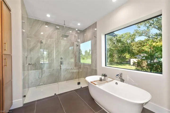 Bathroom with a freestanding tub, tile patterned flooring, a marble finish shower, and recessed lighting