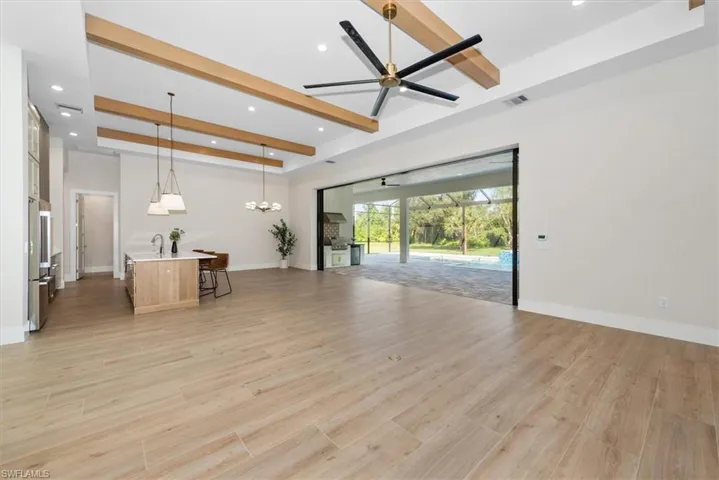 Unfurnished living room featuring beam ceiling, light wood-style floors, a sunroom, ceiling fan, and recessed lighting