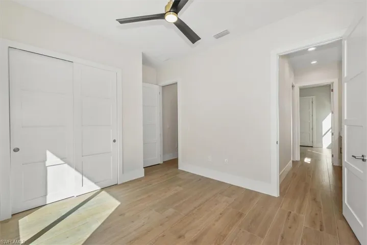 Unfurnished bedroom with light wood-type flooring, ceiling fan, a closet, and recessed lighting