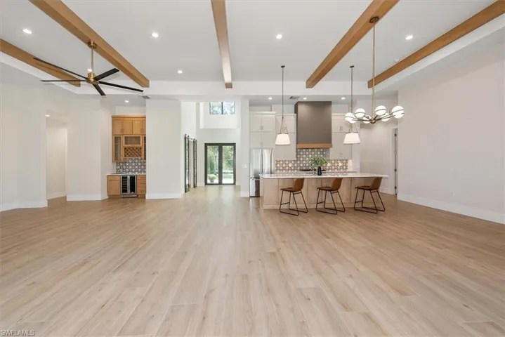 Kitchen featuring backsplash, open floor plan, a large island, recessed lighting, and a breakfast bar area