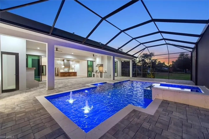 View of pool with a sunroom, glass enclosure, ceiling fan, a patio area, and a pool with connected hot tub