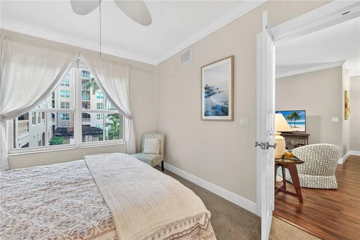 Bedroom featuring ornamental molding, a ceiling fan, and wood finished floors