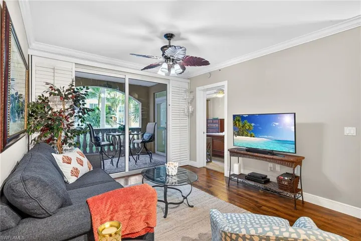 Living area with ornamental molding, hardwood / wood-style floors, and a ceiling fan