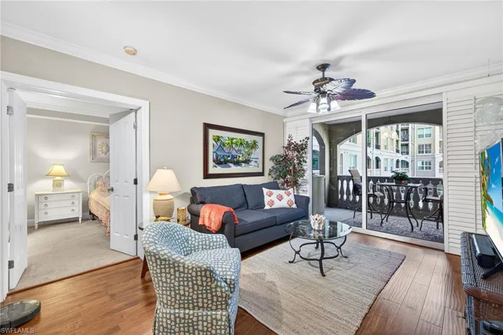 Living area featuring a ceiling fan, ornamental molding, and hardwood / wood-style flooring