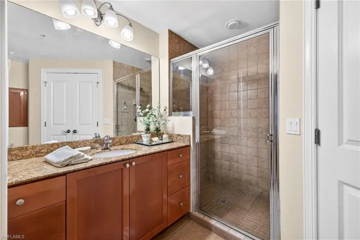 Bathroom featuring vanity, a shower stall, and light tile patterned floors