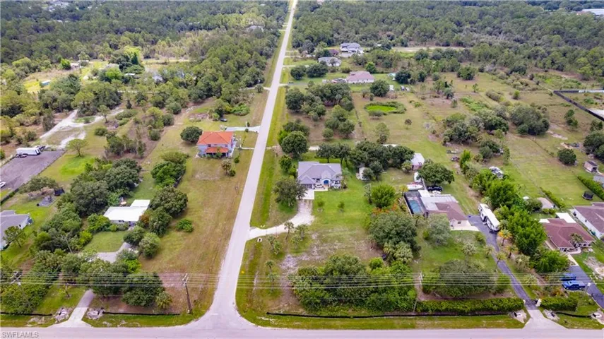 Expansive aerial landscape featuring a residential property surrounded by mature trees and natural vegetation