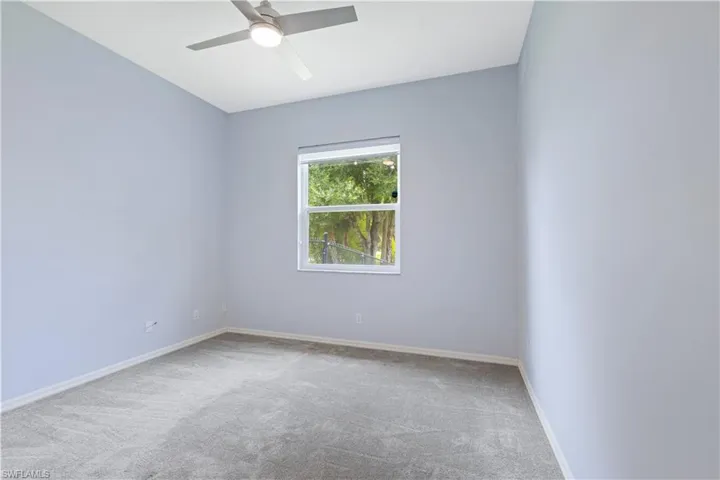 Room featuring soft gray carpeting, light blue wall paint, and white baseboards