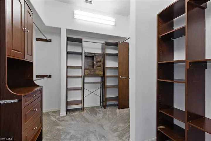 Custom closet system featuring dark wood-finish cabinetry