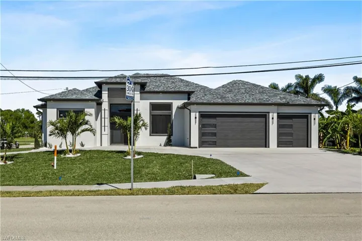 View of front of property featuring a garage and a front yard