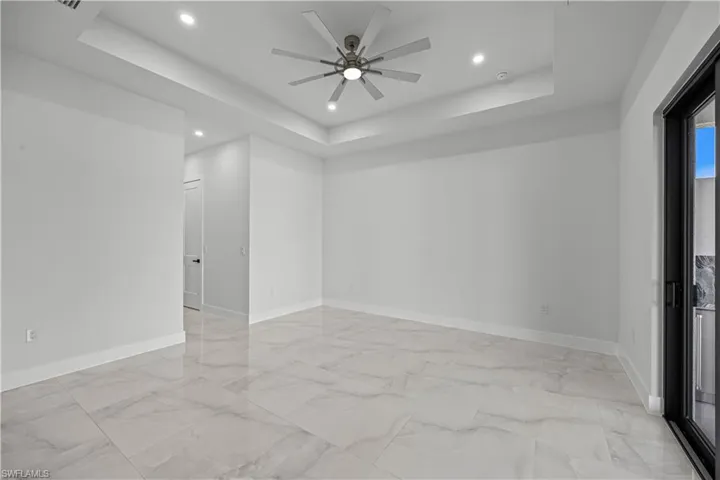 Spare room with a tray ceiling and ceiling fan