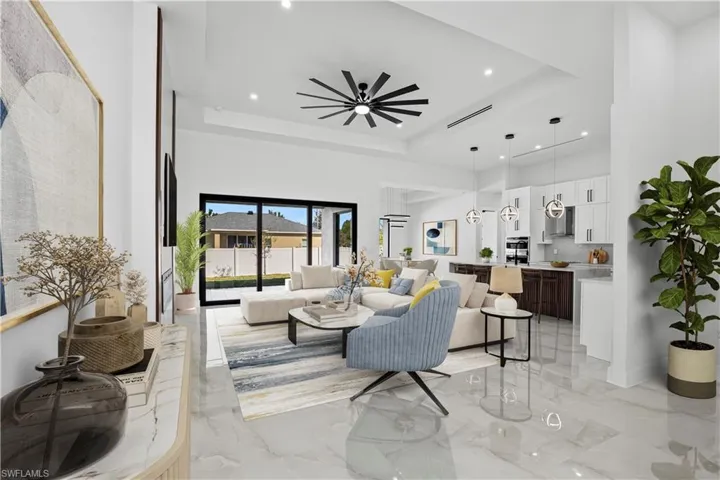Living room DIGITALLY STAGED  featuring a raised ceiling, ceiling fan