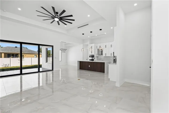 Hallway with a tray ceiling and a high ceiling