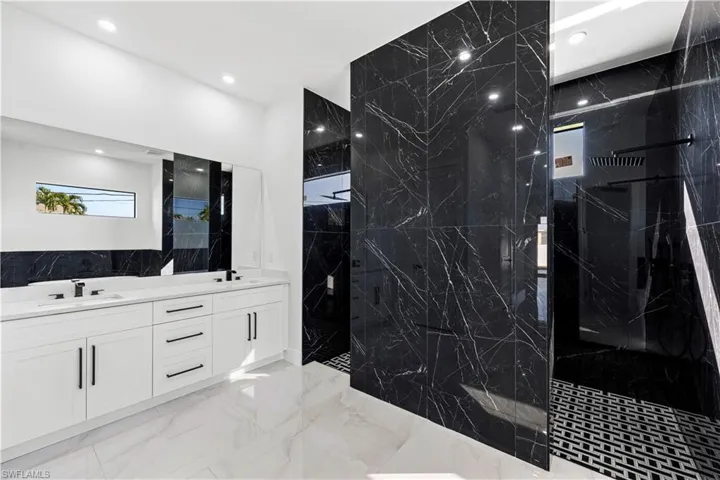 Bathroom featuring vanity and a tile shower