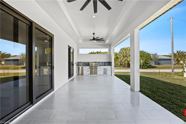 Unfurnished sunroom with ceiling fan and a tray ceiling