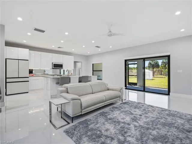 Living area featuring a ceiling fan, recessed lighting, and light tile patterned flooring