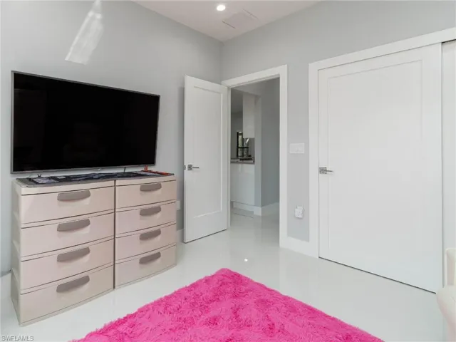 Bedroom with light tile patterned flooring and recessed lighting