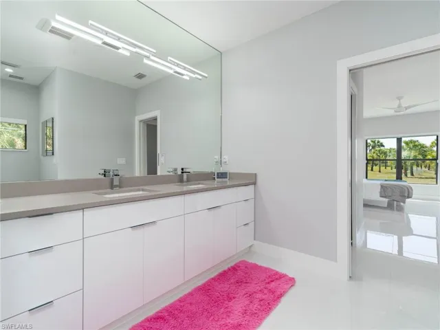 Bathroom with double vanity and baseboards