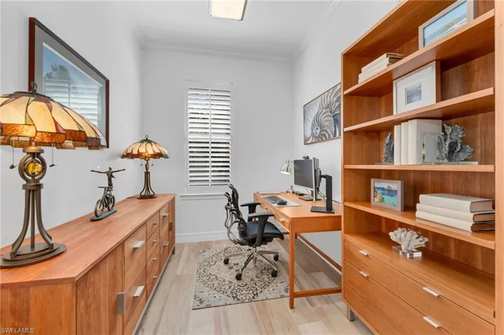 The office has plenty of space for storing files and family pictures on the shelves.