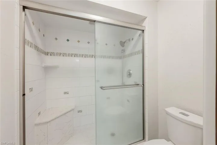 Large Primary Step In Tiled Shower and Toilet Close Off From Sink Area