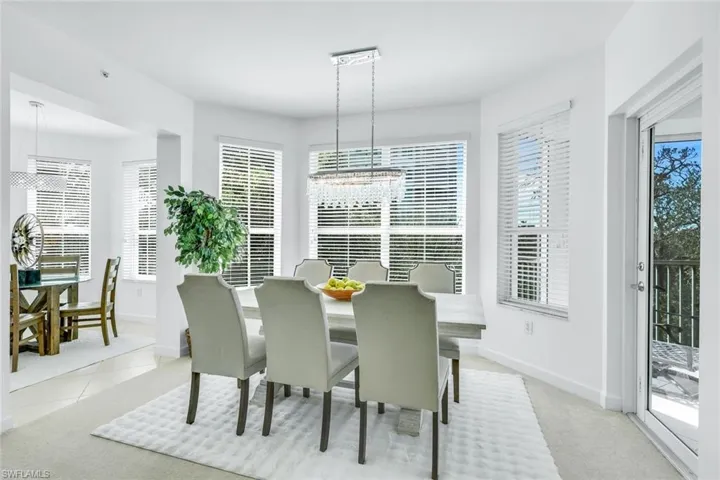 Dining space with a chandelier, light colored carpet, and light tile patterned floors