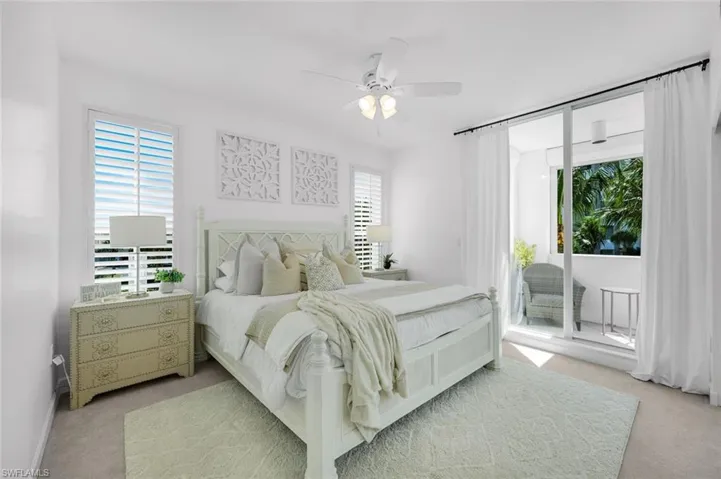 Bedroom featuring light colored carpet, a ceiling fan, and access to outside