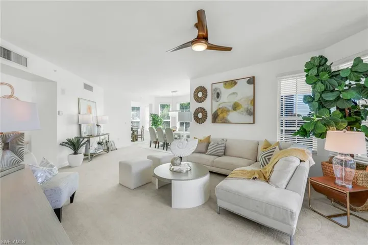 Carpeted living area featuring healthy amount of natural light and a ceiling fan