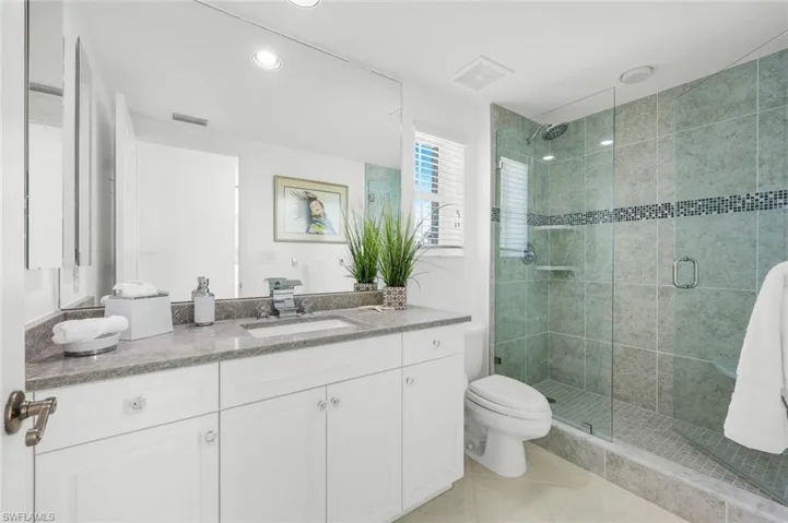 Full bathroom with a shower stall, vanity, light tile patterned floors, and recessed lighting