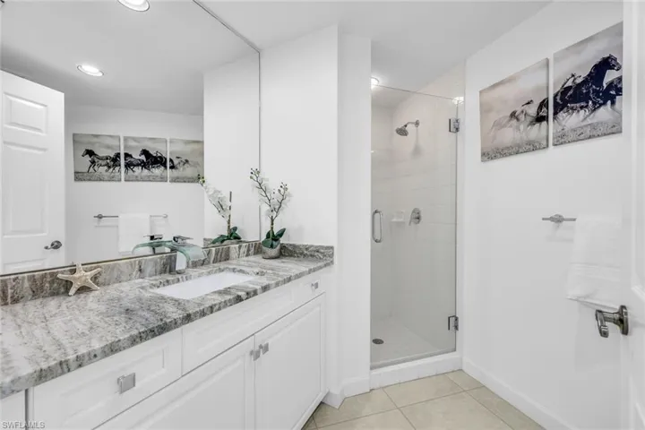 Full bathroom with vanity, a shower stall, and light tile patterned floors