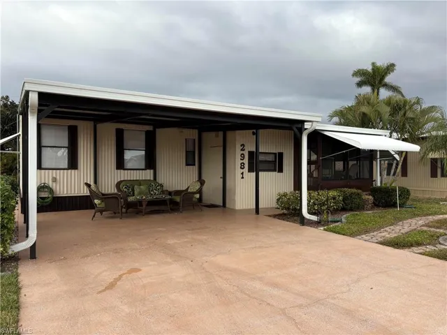 Manufactured / mobile home featuring an outdoor hangout area and a carport