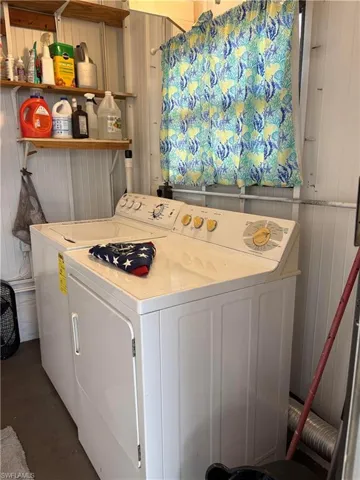Laundry room with washing machine and dryer and wooden walls