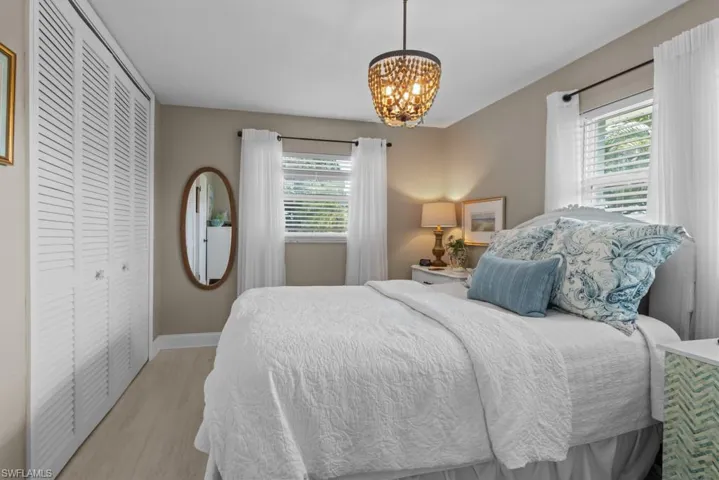 Bedroom with a closet, hanging lights, and wood finished floors