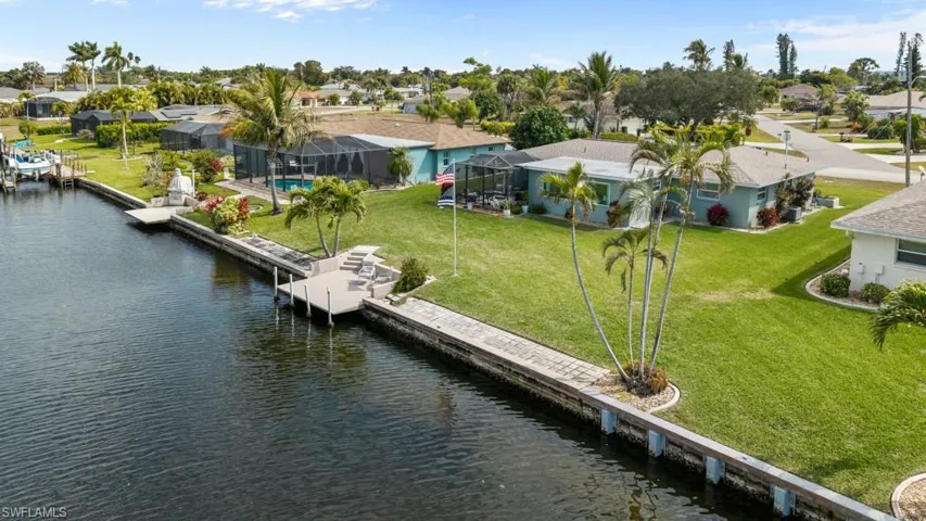 Dock area with a water view, a residential view, and a yard