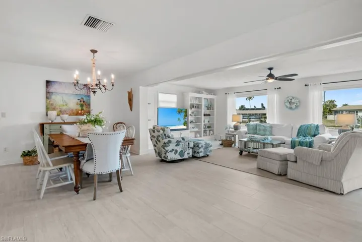 Dining space with light wood finished floors, suspended lighting, and a ceiling fan