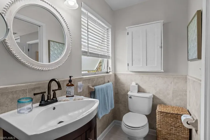 Bathroom with vanity, tile walls, and a wainscoted wall