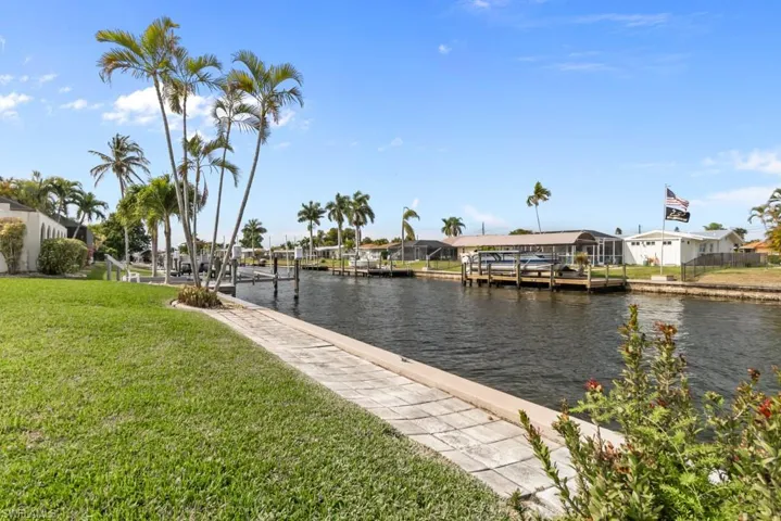 Dock featuring a residential view, a lawn, and a water view