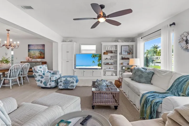 Living area with suspended lighting, wood finished floors, and a ceiling fan