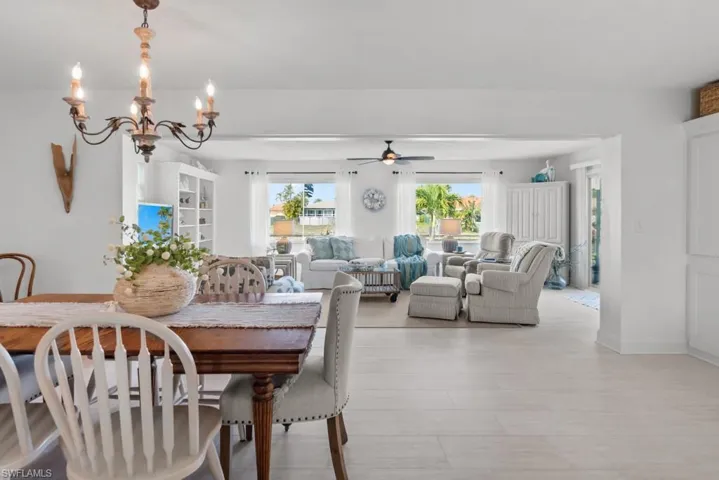 Dining area with a chandelier, ceiling fan, and wood finished floors