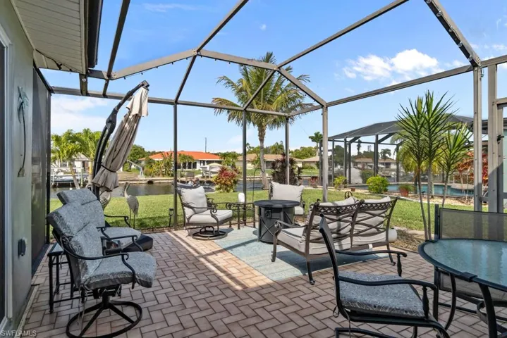 View of patio / terrace with a sunroom, glass enclosure, a water view, a pool, and a residential view